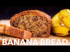 a banana bread is cut in half and sitting on a cutting board next to some bananas