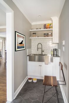 a kitchen with white cabinets and gray flooring