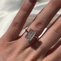 a woman's hand with a ring on it and a diamond in the middle