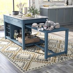 a blue kitchen island sitting on top of a rug