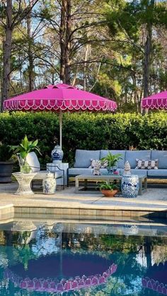 an outdoor pool with lounge chairs and umbrellas next to the swimming pool in front of it