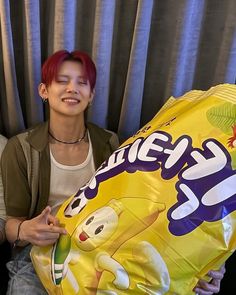 two people sitting next to each other holding a large bag of candy and smiling at the camera