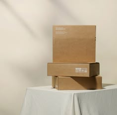 three boxes stacked on top of each other on a white tablecloth covered table cloth