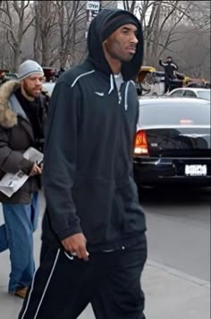 a man in a hoodie walking down the street