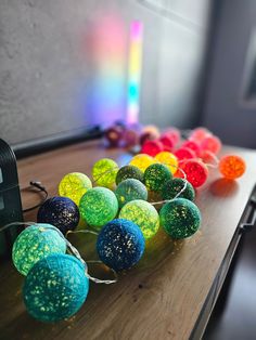 there are many balls on the table with string attached to them and one has a camera in front of it