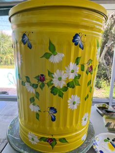 a yellow flower pot with butterflies painted on it