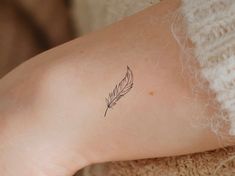 a small feather tattoo on the left ankle and right leg, with an arrow in the center