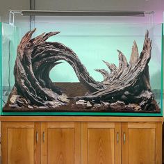 a large fish tank filled with water next to a wooden cabinet