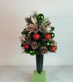 a christmas tree with ornaments in a vase