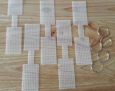 several pairs of scissors sitting on top of a wooden table next to perforated squares