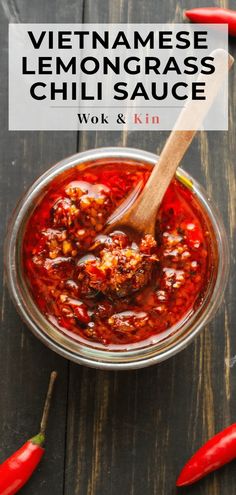 a bowl filled with chili sauce next to red peppers