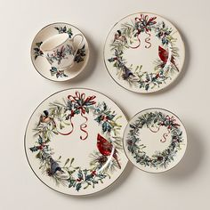 three plates with christmas decorations on them and one has a red bird in the center