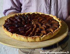 a man holding a plate with a pie on it