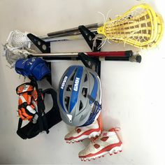 lacrosse stick wall rack Wall Rack Design, Kayak Storage Garage, Door Mounted Spice Rack, Skateboard Storage, Tool Wall Storage, Sports Equipment Storage, Stick Storage, Lacrosse Stick, Field Hockey Sticks