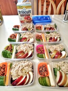 a table topped with lots of trays filled with different foods and veggies