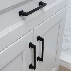 black handles on white cabinets in a bathroom