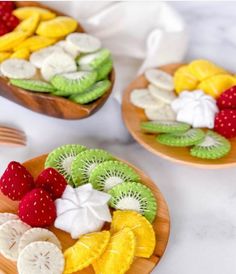 two plates filled with sliced fruit on top of a table