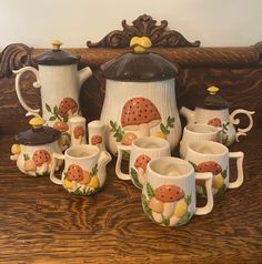 a wooden table topped with lots of white coffee cups and saucers filled with mushrooms