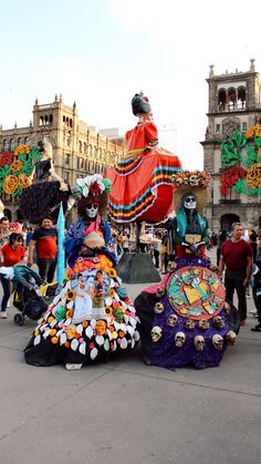 a group of people standing around in front of a building with decorations on the ground