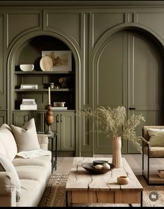 a living room filled with lots of furniture and walls painted green in shades of beige