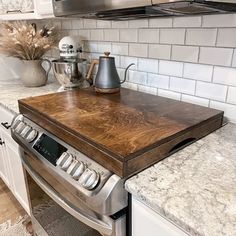 a stove top sitting in the middle of a kitchen next to an oven and microwave