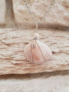 This seashell was found on the beach in Hilton Head, SC.  I wrapped in sterling silver wire and adorned it with a swarovski pearl.  It hangs from a sterling silver chain that is 18 inches long.  It's closure is a sterling lobster claps. Elegant Silver Strand Jewelry, Sterling Silver Shell-shaped Pearl Pendant, Pearl Charm Strand Jewelry Gift, Pearl Charm Strand Jewelry As Gift, Silver Necklace With Pearl Charm For Beach, Beach Jewelry: Silver With Pearl Charm, Beach Jewelry With Silver Pearl Charm, Silver Shell-shaped Pendant With Lobster Clasp, Silver Wire Wrapped Jewelry For Beach