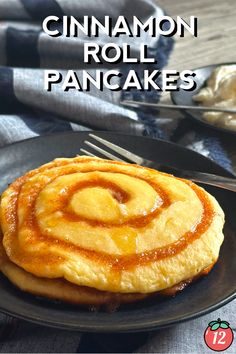 cinnamon roll pancakes on a black plate with fork and napkin in the background, text overlay reads cinnamon roll pancakes