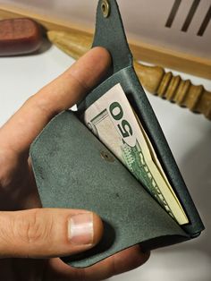 a person holding a wallet with money in it