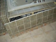 a bath tub sitting inside of a bathroom next to a tiled floor