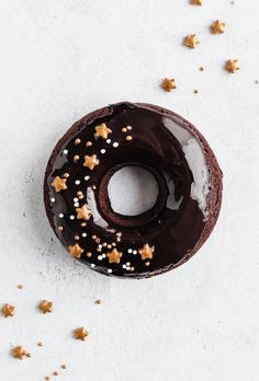 a chocolate donut with white and gold sprinkles on it's side