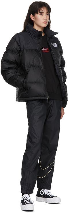 Long sleeve down-filled quilted wind and water-resistant nylon ripstop jacket in black. Cord-lock drawstring and Velcro fastening at stow-away hood. Stand collar. Zip closure at front. Logo embroidered in white at chest and back. Zippered pockets at waist featuring concealed integrated stow-away pocket. Concealed drawstring with cord-lock fastening at hem. Press-stud and Velcro fastenings at partially elasticized cuffs. Zippered pocket at interior. Fully lined. Tonal and gunmetal-tone hardware. North Face Clothing, 1996 Retro Nuptse Jacket, Retro Nuptse Jacket, North Face Outfits, Nuptse Jacket, Black North Face, Press Studs, Logo Embroidered, Luxury Streetwear