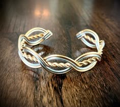 "PLEASE BE SURE TO LET ME KNOW IN A MESSAGE IF YOU PREFER A 6\", 7\", or 8\"+ SIZE CUFF. This fabulous  cuff style bracelet is the perfect accessory to compliment any outfit!  It goes with the Rowan Style Circlet too. Features twist and woven design inspired by Celtic knot work.  Simple, but definitely a statement!  Dress it up or wear it with your favorite T-shirt and a pair of jeans. It is crafted from thick anodized aluminum wire. It is entirely hypoallergenic and all nickel-free. It won't tarnish or turn your skin green either!  Even though it has that nice chunky look, it is light-weight and very comfortable.  Adjustable for a perfect fit every time.  it does help to get a wrist measurement if possible if your wrist is extra small or large. please message me.  Band measures about 3/4\ Celtic Wire Jewelry, Celtic Knot Work, Celtic Knot Jewelry, Celtic Bracelet, Wire Jewelry Rings, Wire Wrap Jewelry Designs, Wire Wrapped Jewelry Diy, Brass Cuff Bracelet, Bijoux Fil Aluminium