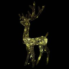 a lighted reindeer standing on top of a black ground with its head turned to the side