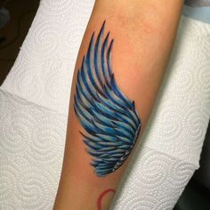 a blue wing tattoo on the arm