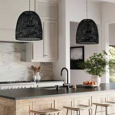 a kitchen with two hanging lights over the island