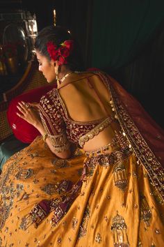 Step into refined elegance with a lehenga that exudes grace and tradition. This stunning piece is infused with a lively story, delicately embroidered on a raw silk lehenga skirt in vibrant mustard, showcasing intricate gold tarnished work, sequins, and old-world zardozi. The blouse, crafted from rich maroon velvet, features lush embroidery that beautifully complements the skirt. Paired with a delicate net dupatta that adds a crowning touch to this luxurious ensemble, this lehenga is truly every bride's dream, blending timeless elegance with contemporary charm. Festive Raw Silk Lehenga With Cutdana, Festive Raw Silk Lehenga With Cutdana Details, Chanderi Lehenga With Resham Embroidery For Navratri, Resham Embroidered Raw Silk Choli For Wedding, Wedding Choli With Resham Embroidery In Raw Silk, Wedding Choli With Resham Embroidery, Anarkali Choli In Raw Silk With Cutdana, Anarkali Style Raw Silk Choli With Cutdana, Gold Embroidered Dola Silk Gown