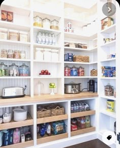 an organized pantry with white shelving and wooden shelves