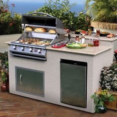 an outdoor bbq grill with food on the counter and potted plants around it