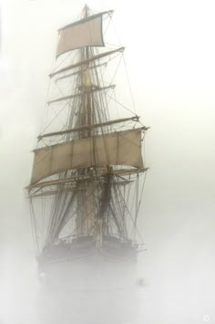 an old sailing ship in the foggy water