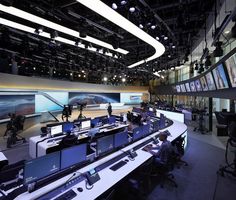 an empty room with multiple monitors and laptops on the tables in front of them