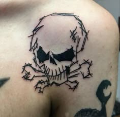 a skull and crossbone tattoo on the back of a man's left shoulder