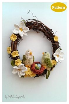 a crocheted wreath with birds and flowers on it