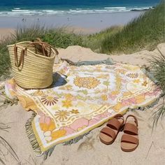 a blanket, sandals and basket on the beach