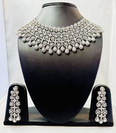 American Diamond Bridal Necklace Set--a perfect blend of elegance and contemporary design, ideal for your special day. Despite its dramatic appearance, the necklace is lightweight, ensuring comfort while wearing it throughout your special day. his necklace pairs beautifully with traditional outfits like lehengas and sarees, as well as modern gowns, adding a touch of glamour to any look Elegant Heavy Kundan Necklace For Party, Elegant Heavy Bridal Necklace, Elegant Silver Bridal Sets For Festive Occasions, Silver Bridal Sets For Formal Festive Occasions, Elegant Heavy Necklace For Festive Occasions, Silver Kundan Necklace For Reception With Elegant Design, Elegant Heavy Necklaces For Festive Occasions, Elegant Heavy Necklaces For Party, Festive Silver Bridal Sets For Formal Occasions