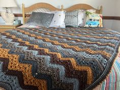 a bed with a crocheted bedspread and pillows on top of it