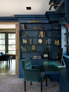 an office with blue walls and built - in bookshelves