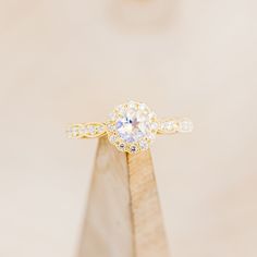 a diamond ring sitting on top of a wooden stand