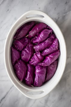 purple cabbage in a white bowl on a marble surface