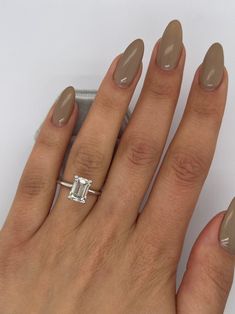 a woman's hand with a ring on it and a diamond in the middle