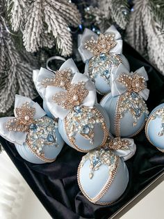 blue and white ornaments are on display in front of christmas trees